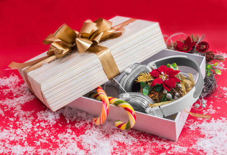 Headphones in a decorative gift box on red background best Christmas gift 2015.の写真素材