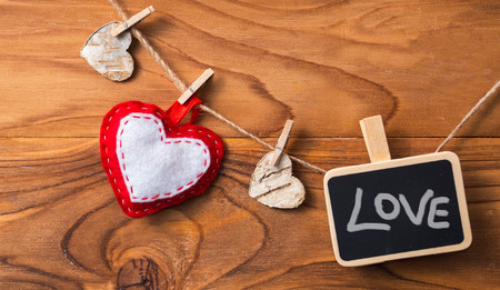 Blank plate with hearts on the clothespin on wooden background.Symbol of love.の写真素材