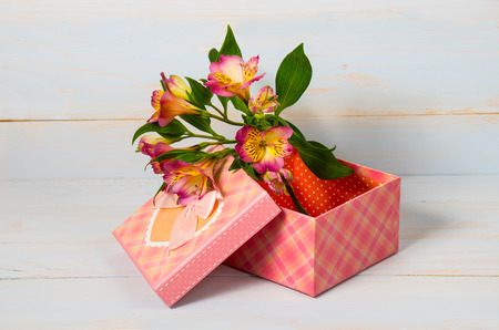 Decorative gift box with flowers on wooden background.の写真素材