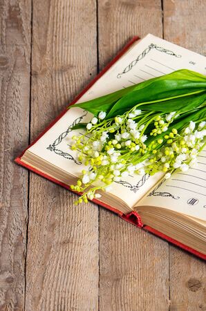 lily of the valley flowers on the book for records  on wooden backgroundの写真素材