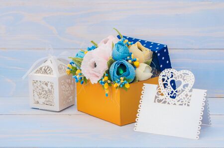 decorative flowers in a gift box with a card for text on wooden backgroundの写真素材