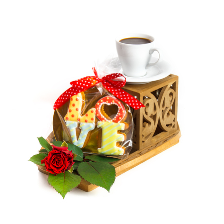Cup of coffee and cookies on Valentine's Day with a red rose on a white background.の写真素材