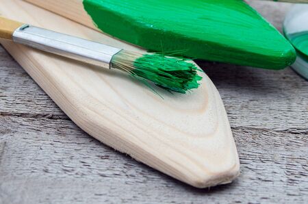 Paintbrush and green paint for painting wooden productsの写真素材