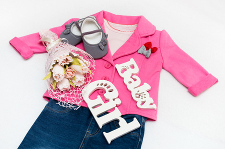 Set of baby girl clothes on holiday. Jacket, leggings, bodykit, booties, a bouquet of flowers.の写真素材
