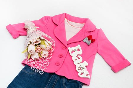 Set of baby girl clothes on holiday. Jacket, leggings, bodykit, booties, a bouquet of flowers.の写真素材