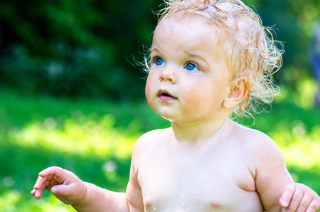 Portrait of a toddler baby girl with blue eyes on a blurred background nature.の写真素材