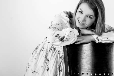 portrait of a beautiful young woman leaning on a chair. shooting studio on a gray backgroundの写真素材