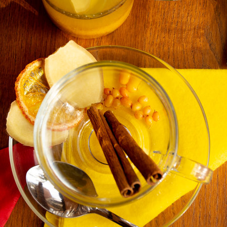 ginger sea buckthorn tea with cinnamon sticks and honey on a wooden tableの写真素材