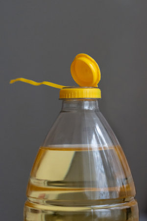 Yellow plastic cap for PET bottle with sunflower oil. New design with less plastic, the cap remains...