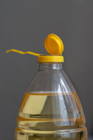 Yellow plastic cap for PET bottle with sunflower oil. New design with less plastic, the cap remains attached to the bottle after opening. Designed to reduce plastic waste.の写真素材