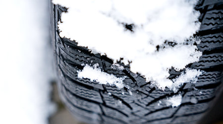 Winter car tire on snow and tread in snow. Close-up of car tires in winter.の写真素材