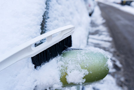 white brush for cleaning snow on green car mirrorの写真素材