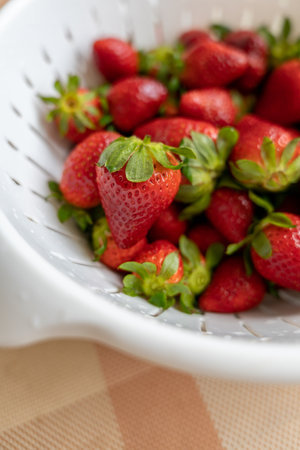 Freshly washed ripe strawberries in a white colander. Soft focus photo. Healthy eating. Fresh seasonal berries. Food hygiene.の写真素材