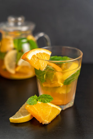 Glass of cold orange drink with citrus slices on a dark background. Natural refreshing drink, diet drinks, healthy food.の写真素材