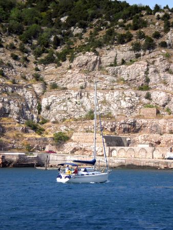 White sailboat with sails lowered is the bay in sunny day        の写真素材