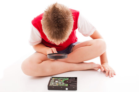 the boy checked the hard disk with a magnifying glass
