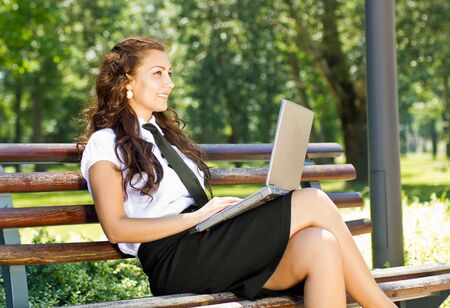business woman in the park working on laptopの写真素材