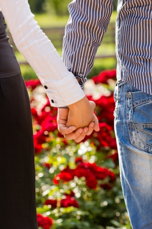 man and woman holding hands outdoorsの写真素材