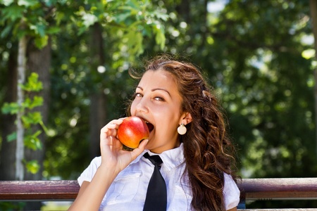 businesswoman have break and eating apple in parkの写真素材