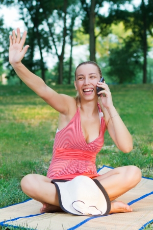 beautiful  women enjoy in the park and talking with mobile phoneの写真素材
