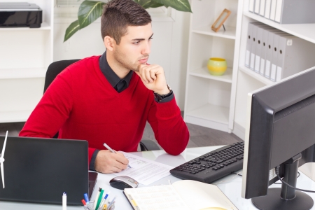 successful businessman in red sweart thinking about workの写真素材