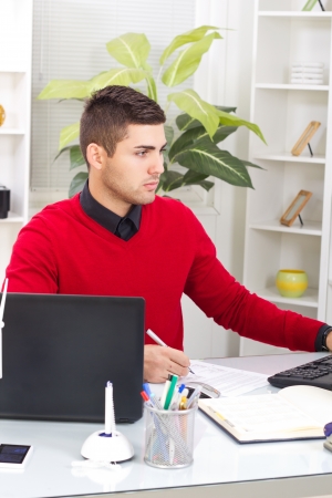 successful businessman in red sweater,signs a contractの写真素材