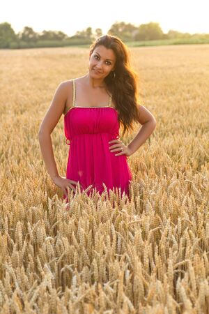 Woman in golden wheat fieldの写真素材