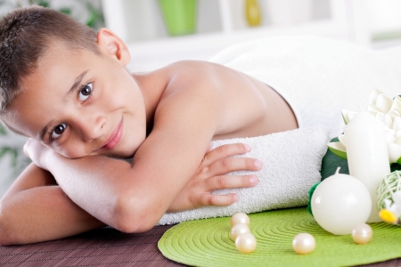 Smiling boy lying on the massage table in spa saloonの写真素材