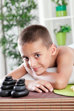 young boy lying in massage tableの写真素材