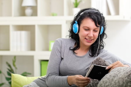 young smiling  woman with blue headphones at home listening  musicの写真素材