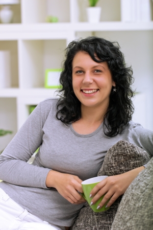  beautiful woman drinking tea at home on the sofaの写真素材