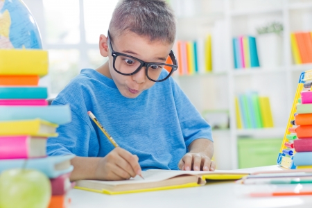 little scientist with glasses writing his homeworkの写真素材