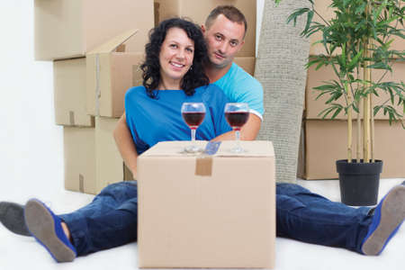 pair sitting on floor sorrounded with boxの写真素材