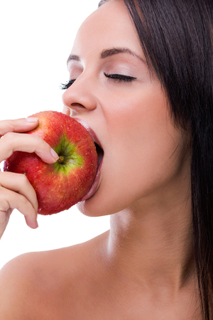 Beautiful young woman eating appleの写真素材