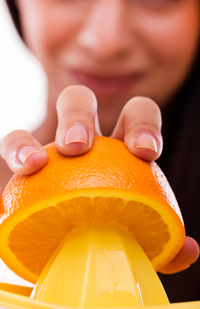 Woman straining an orange in order to get orange-juiceの写真素材