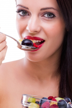 Beautiful woman eating fresh fruit saladの写真素材