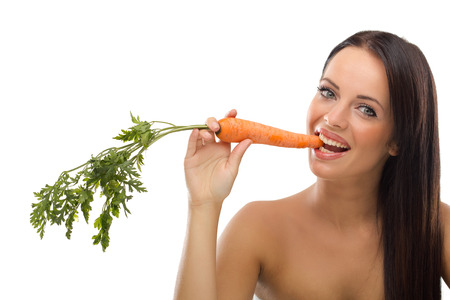 beautiful funny woman biting raw carrot, healthy foodの写真素材