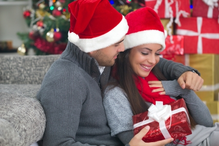  boy surprising a girl with a gift in Christmas nightの写真素材