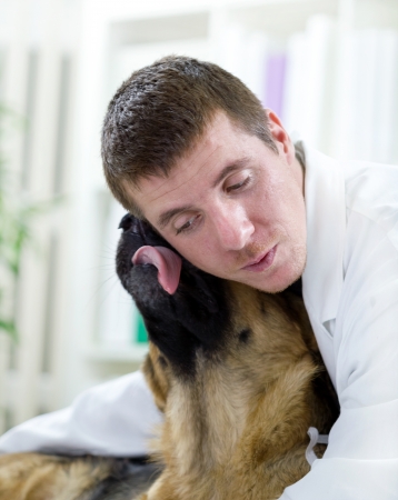 veterinarian hugging German  Shepherd dogの写真素材