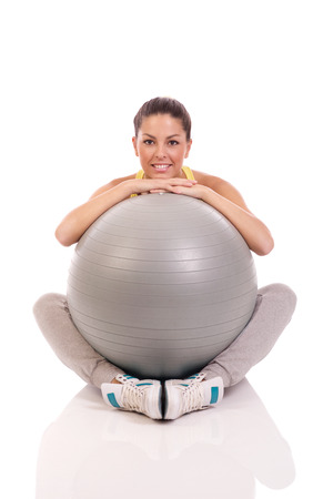 attractive young woman exercising with exercise ball の写真素材