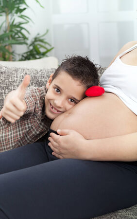   little boy and his pregnant mother spend time togetherの写真素材