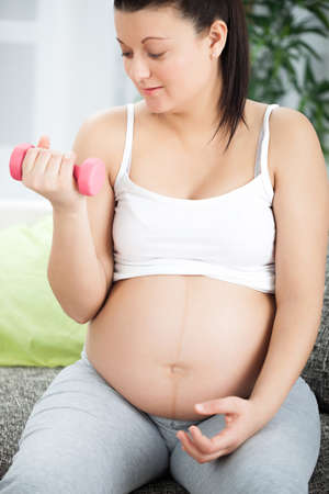 Pregnant Woman Lifting Weights  at homeの写真素材