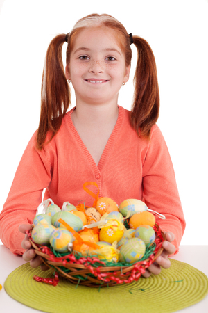 Beautiful girl  with pigtails holding Easter eggs basketの写真素材