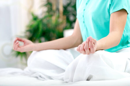 Close up portrait of a young woman in lotus position with yoga handsの写真素材