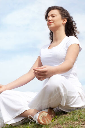 Beautiful young woman doing yoga outsideの写真素材