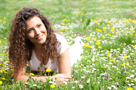 beautiful girl laying on flowers field,outdoor portrait summerの写真素材