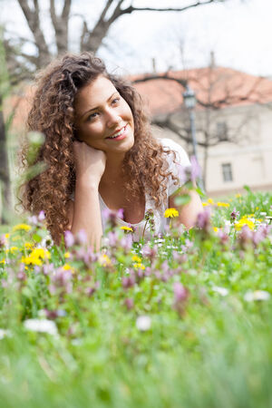 beautiful girl laying on flowers fieldの写真素材