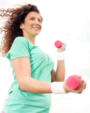 Portrait of Beautiful young woman exercising with weights の写真素材