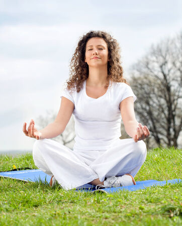 Attractive young woman in a lotus positionの写真素材