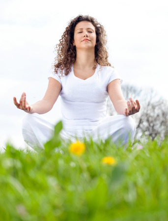 Attractive young woman in a lotus positionの写真素材